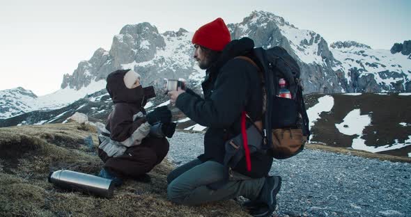 Hiker Family Sharing Hot Tea Drink on His Travel Adventure to Hight Mountain