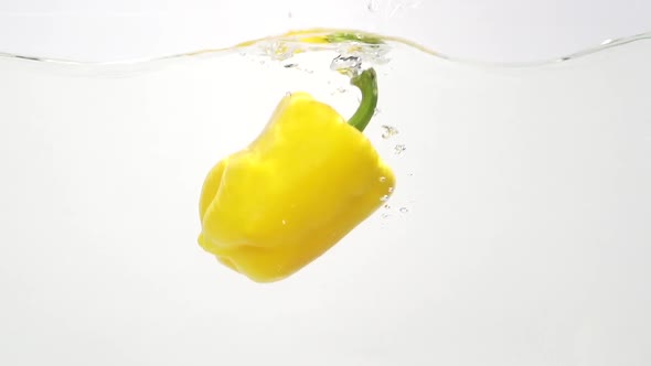 Yelow Paprika Splashing Into Water in Slowmotion