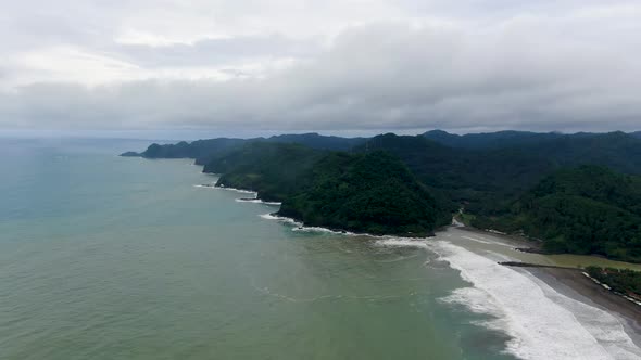 Lush vegetation on green cliffs of Suwuk beach in Kebumen district, Indonesia. Aerial panoramic view