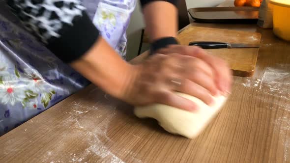 The woman kneads the dough