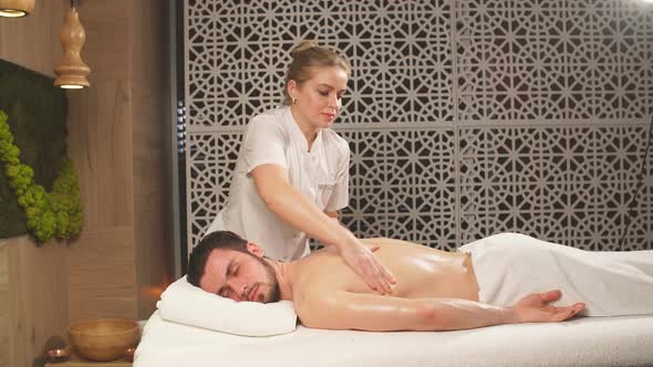 Pleasant Dark-haired Guy Is Getting Massage for Spine