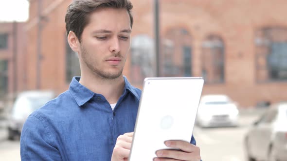 Outdoor Portrait of Young Man Using Tablet