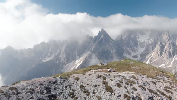 Aerial Spin Around Man Hiker In Front of Cadini Mountain in Dolomites Italy