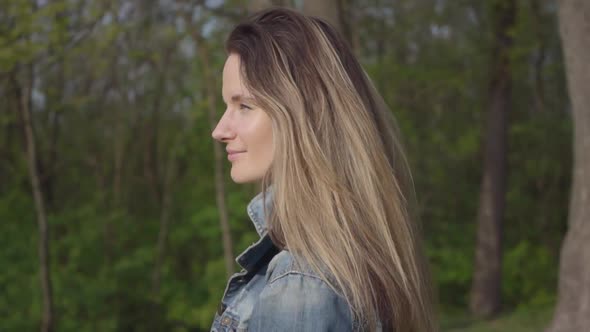 Portrait of a Beautiful Smiling Young Woman Wearing a Denim Jacket Walking on a Beautiful Sunny Day