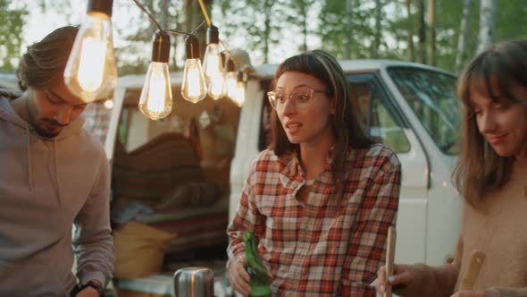 Young Friends Preparing Dinner and Chatting at Campsite