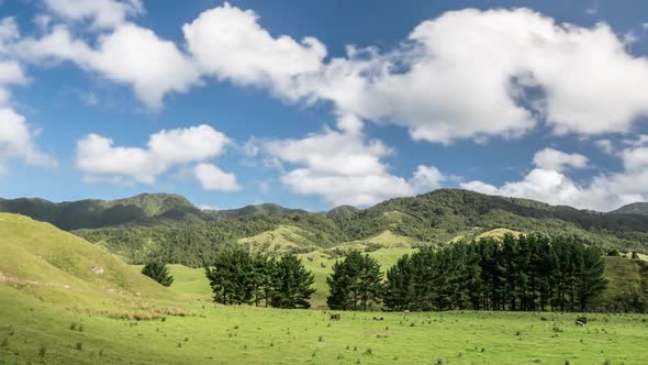 Sky Clouds over Green Mountains and Farm Land in New Zealand Nature Landscape