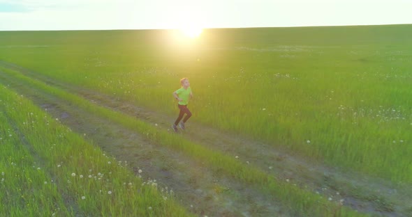 Sporty Child Runs Through a Green Wheat Field