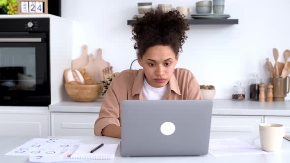 Excited Joyful African American Curly Girl Manager Stock Broker Designer Looks at the Laptop Screen