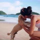 Happy Smiling Beautiful Asian Woman in Swimsuit Playing with Her Cute Dog on the Tropical Beach - VideoHive Item for Sale