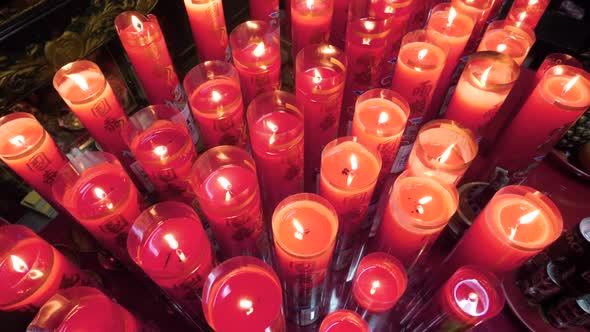 Slow motion shot of red candlelights in dark temple in Taipei, Taiwan