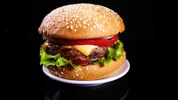 Appetizing burger on a black background. Delicious fast food.