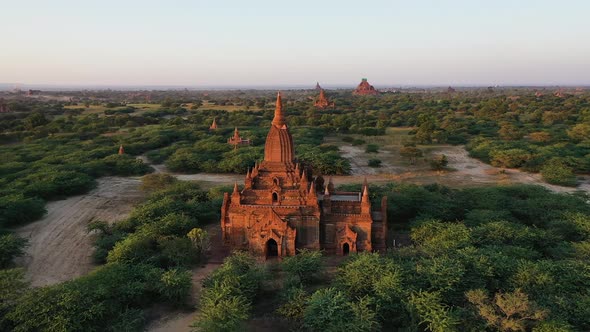 Astonishing golden sunset over the Bagan, ancient city of the temples. Aerial orbiting shot around t