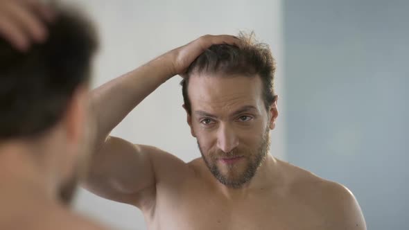 Male Narcissist Adjusting His Hairstyle in Front of Mirror and Brazenly Grinning