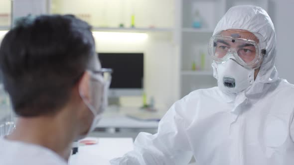 Doctor in Protective Gear Talking to Contagious Patient