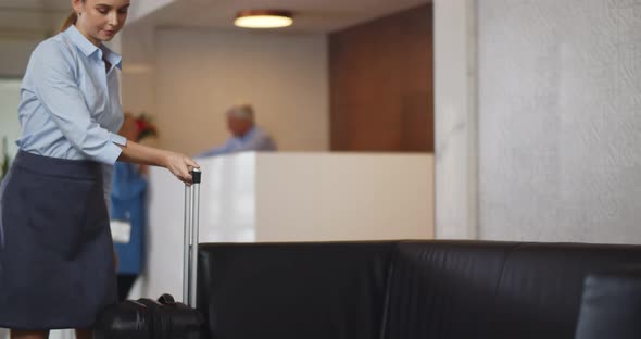 Businesswoman with Luggage in Modern Hotel Lobby Waiting for Taxi