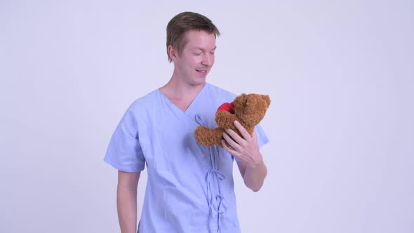 Happy Young Man Patient Holding Teddy Bear and Acting Childlike