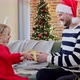 Father gives a Christmas gift to his daughter dressed in festive red dress - VideoHive Item for Sale