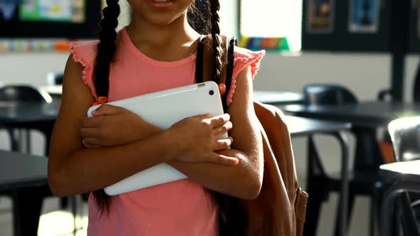 Schoolgirl holding digital tablet in classroom 4k