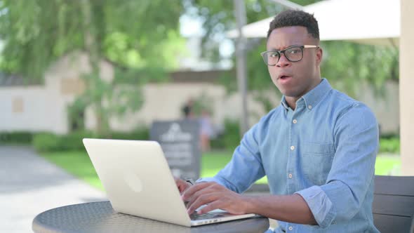 African Man with Laptop Feeling Shocked Outdoor