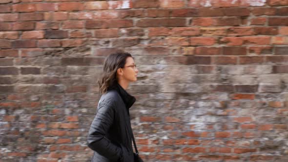 Profile Shot of a Young Woman with a Brick Background.