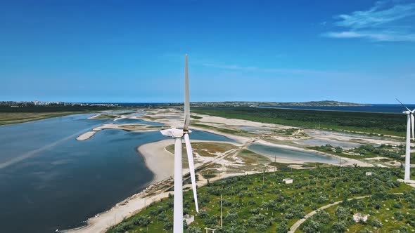 Flying Above Elegant Ecological Wind Turbines on Green Sunny Hills