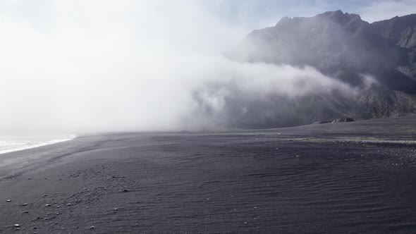 Drone Flight Over Black Sand Beach To Sea