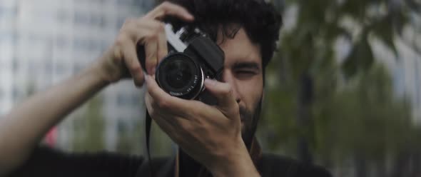 Man with beard taking pictures in the city center