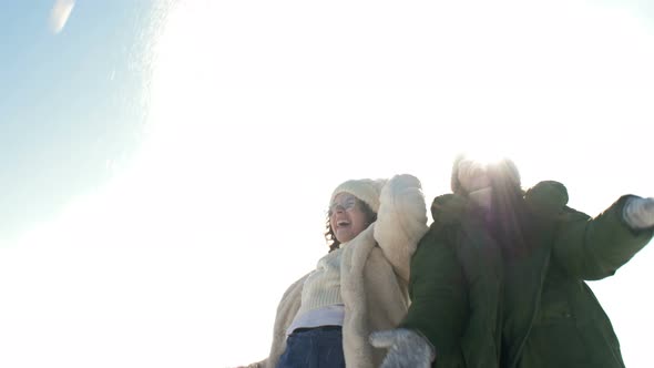 Cute Teenage Girl and Her Older Sister or Mom are Playing with Snow During a Winter Walk