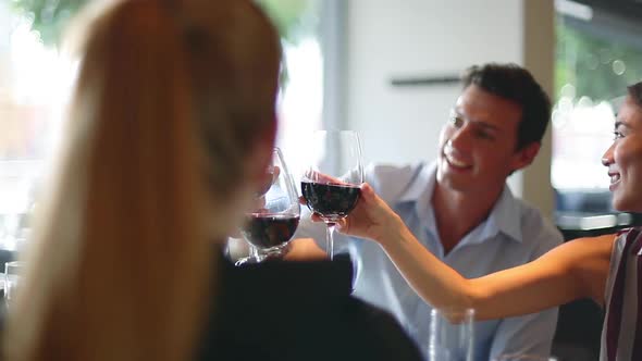 Friends clinking red wine glasses