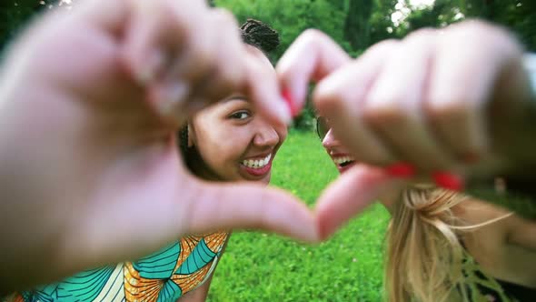 Two young women sending love to the camera