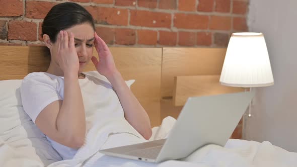 Young Indian Woman having Headache while Working on Laptop in Bed