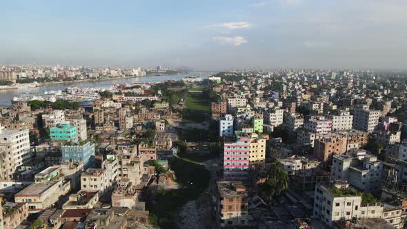 Aerial across urban Dhaka city showing dry canal used as industrial garbage dump