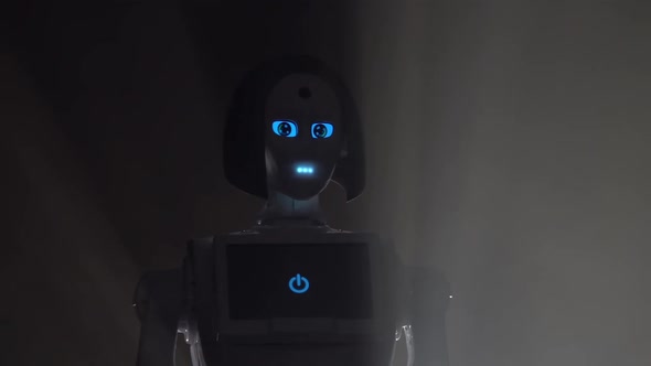 Robot Leaves the Darkness in the Room . Black Smoke Background. Close Up