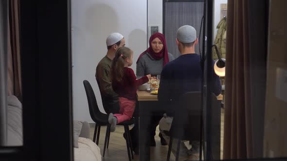 Muslim Family with Children Have Dinner Together at Home in the Evening