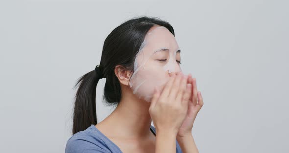 Young Woman apply paper mask on face