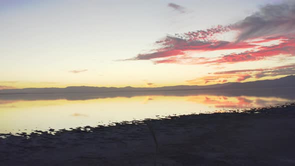 Flying towards lake reflecting sky at sunset. Pink clouds. Salton Sea