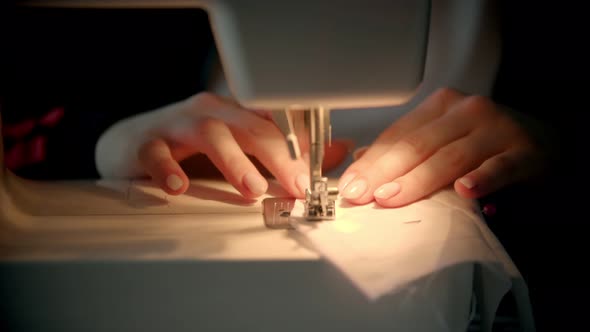 Young Woman Sewing a White Cloth