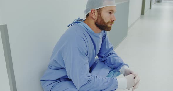 Side view of worried Caucasian male doctor walking in the corridor