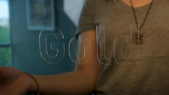 Woman Holding Glass Gold Sign alt