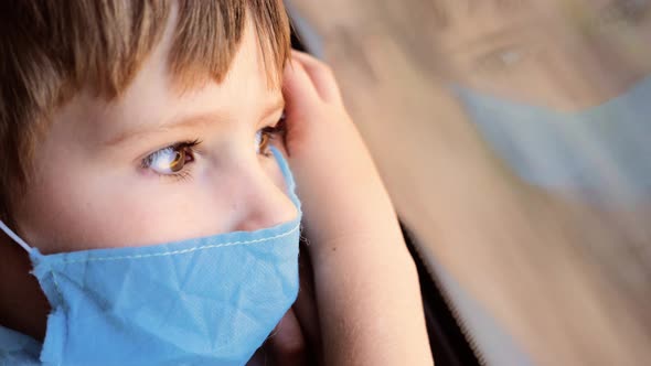 Child Traveling By Train Watching How Fast the Road Moves. Sun Light on the Face in Medical Blue