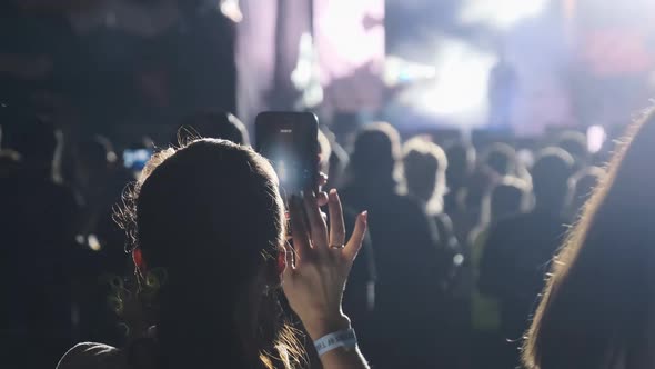 Woman Hands Silhouette Recording Video of Live Music Concert with Smartphone