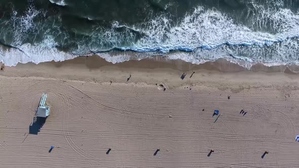 Birds eye view of waves on beach, shot on a drone looking directly down at amazing waves washing ove