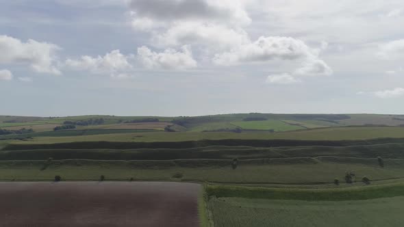 Aerial tracking back centring on the grand iron age hill fort, Maiden Castle. Dorchester, Dorset. Am