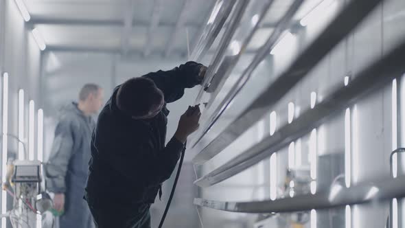 Two Men at Work in the Paint Shop