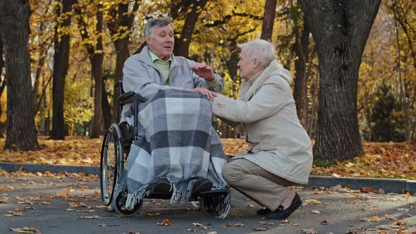 Caucasian Female Elderly Greyhaired Woman Holding Husband Hand Senior Man with Disability on
