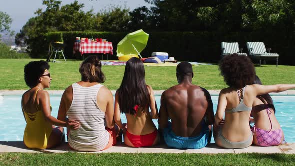 Diverse group of friends sitting in a row at a pool party