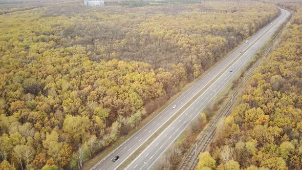 Aerial View of Road Between Forests in Countryside