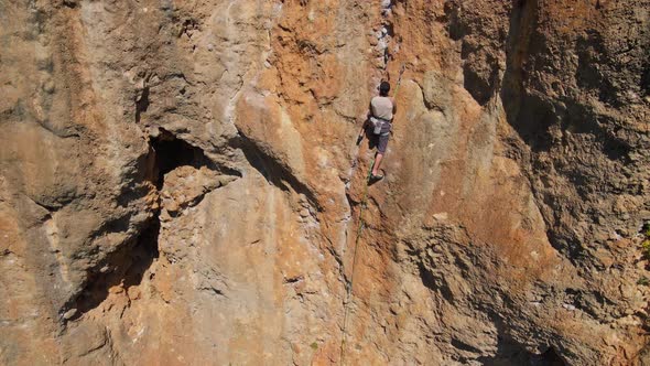 Slow Motion Back View Man Rockclimber Climbs on Overhanging Crag