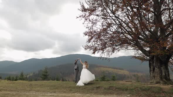 Lovely Newlyweds Bride Groom Dancing on Mountain Autumn Slope in Slow Motion Wedding Couple Family