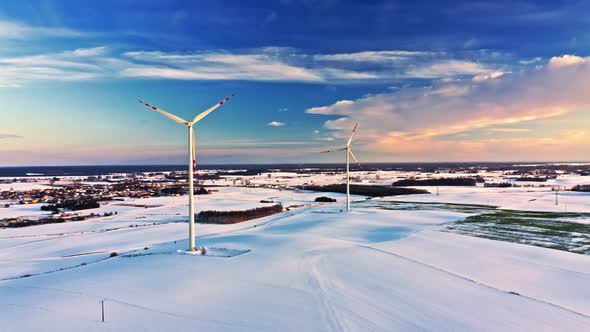 Snowy field and wind turbine. Alternative energy in winter.